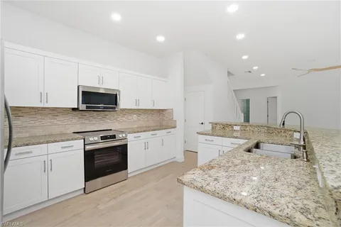 a kitchen with sink stove and cabinets
