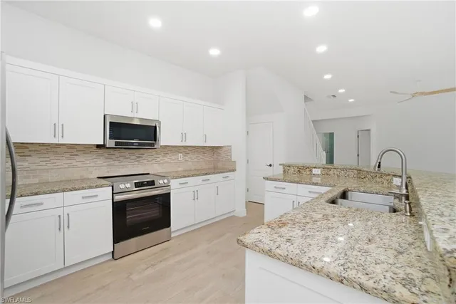 a kitchen with sink stove and cabinets