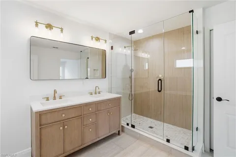 a spacious bathroom with a double vanity sink a toilet and a mirror