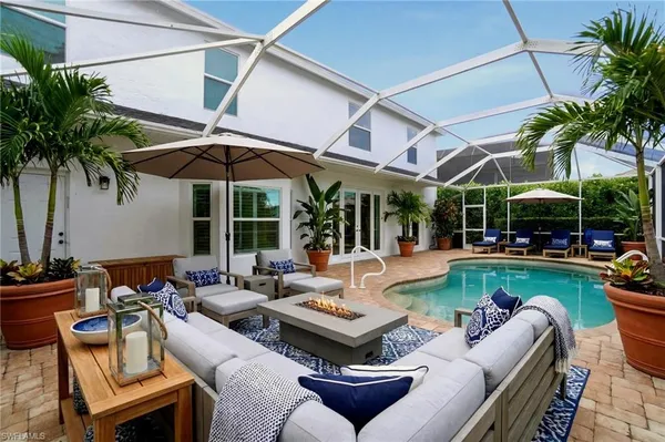 a view of a patio with couches and chairs under an umbrella