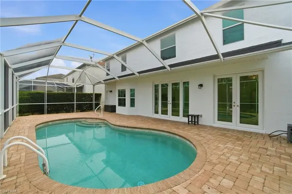 a view of a patio with couches and chairs under an umbrella