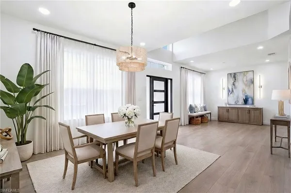 a view of a dining room and livingroom with furniture wooden floor a chandelier