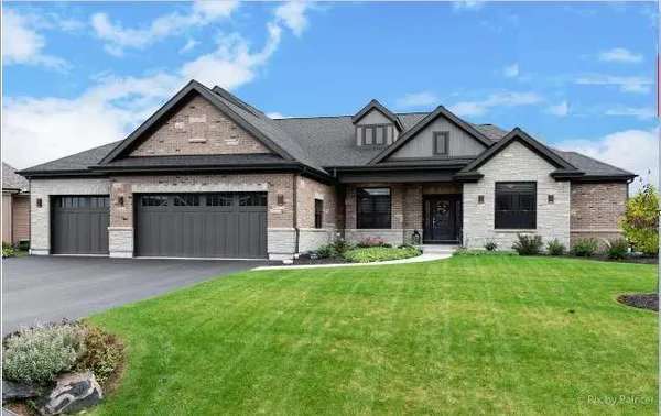 a front view of a house with a garden and yard