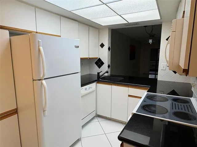 a view of swimming pool with lawn chairs and plants