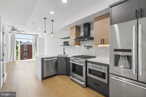 a kitchen with stainless steel appliances granite countertop a stove a refrigerator and a sink