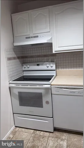 a stove top oven sitting inside of a kitchen