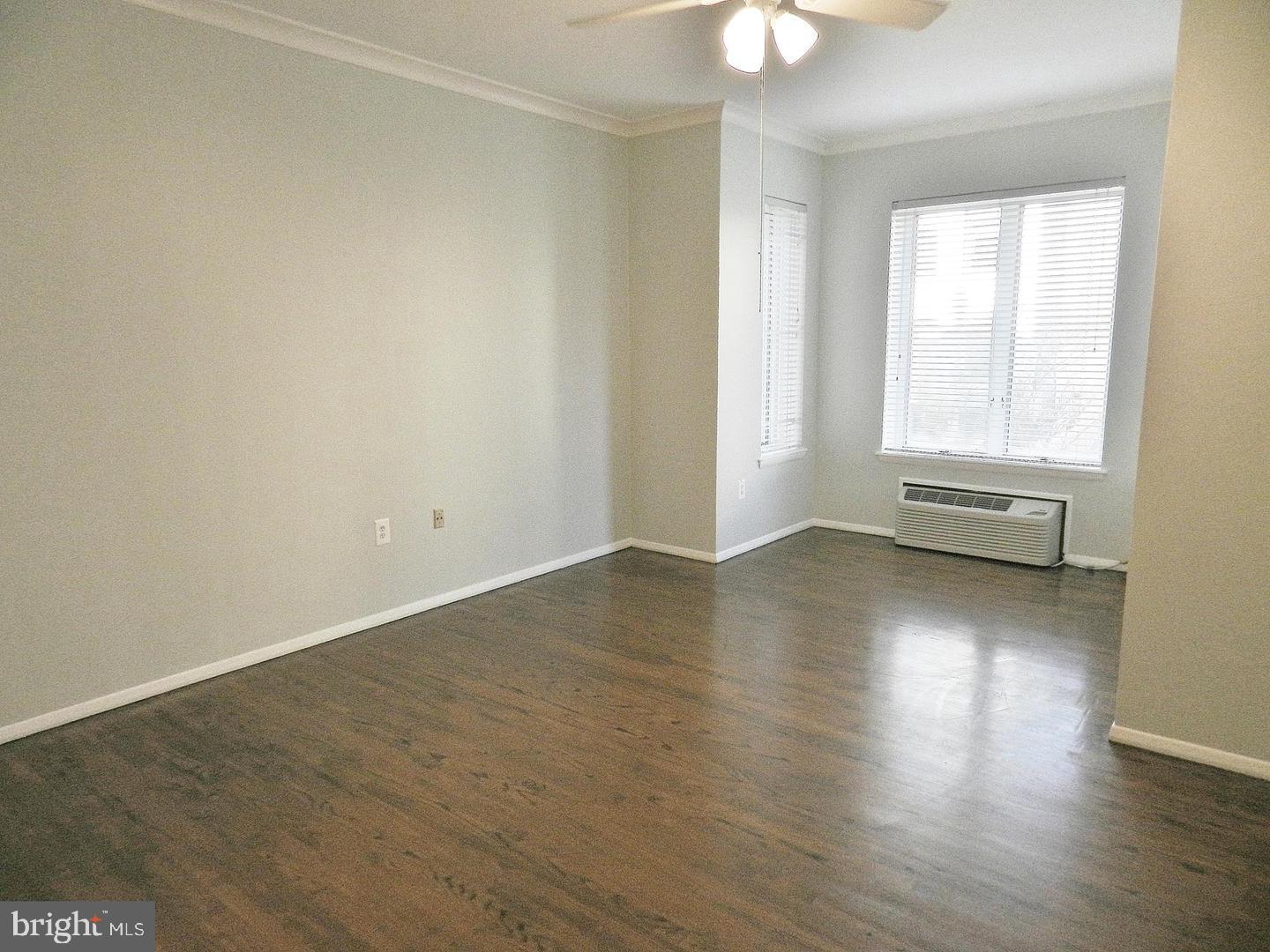 2120 N Street Northwest, Unit 101 Washington, DC 20037 - Photo 9 of 21 an empty room with wooden floor and windows