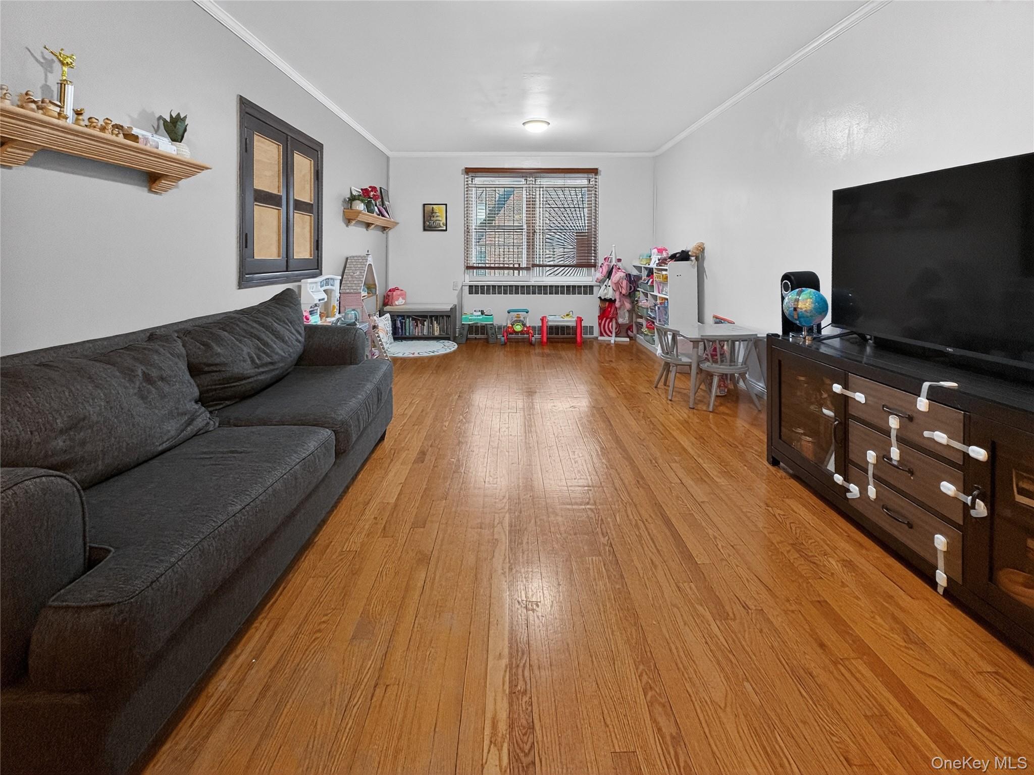 65-70 Booth Street, Unit 6F Queens, NY 11374 - Photo 3 of 11 a living room with furniture and a flat screen tv