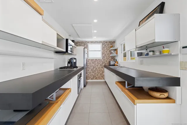 a kitchen with stainless steel appliances granite countertop a sink stove and microwave