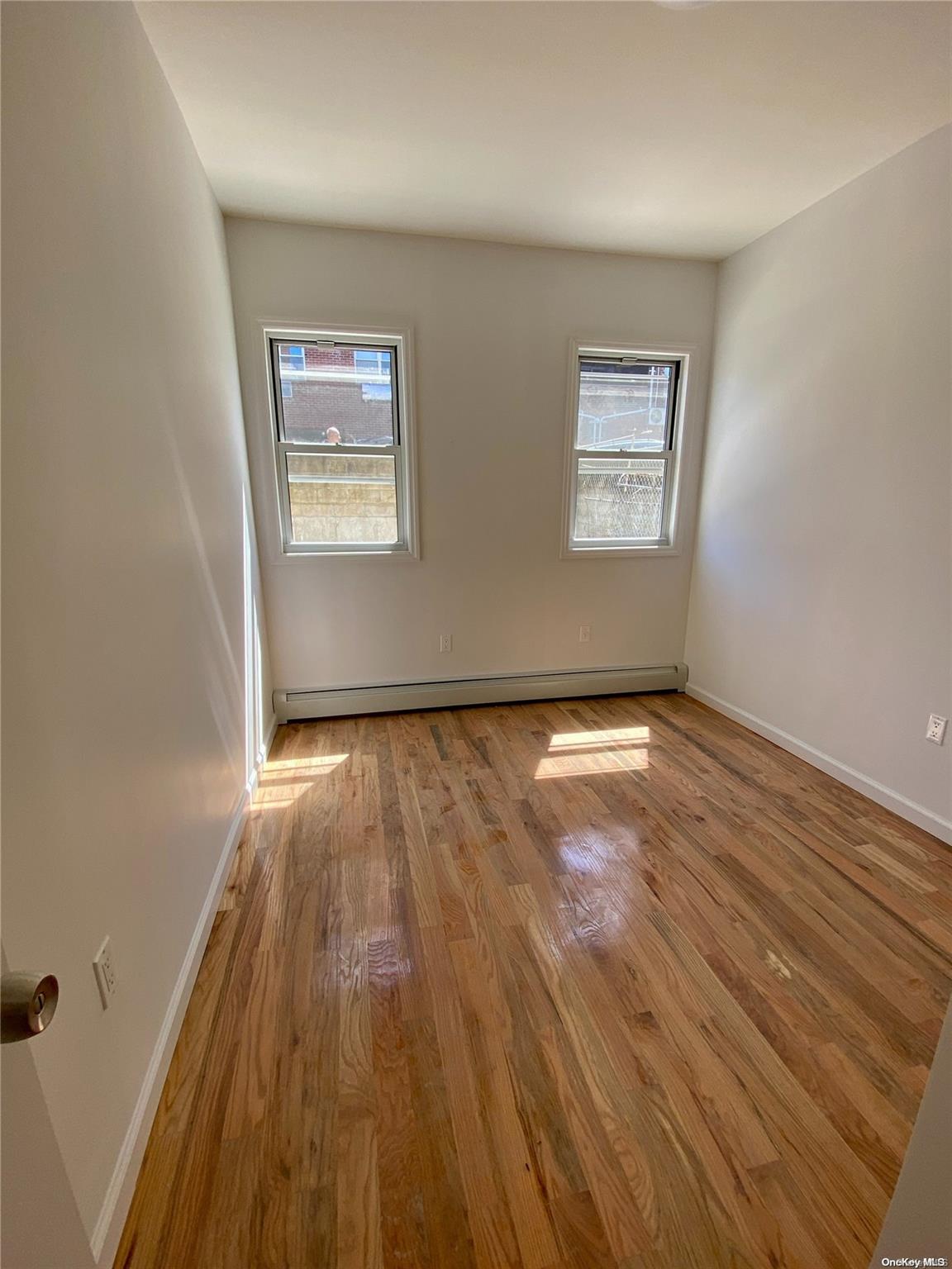 108-14 37th Avenue Queens, NY 11368 - Photo 14 of 22 an empty room with wooden floor and windows