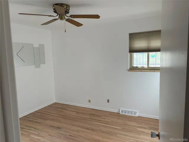 a view of a livingroom with wooden floor and a ceiling fan
