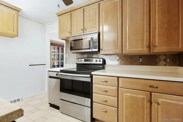 a kitchen with stainless steel appliances granite countertop a sink stove and microwave