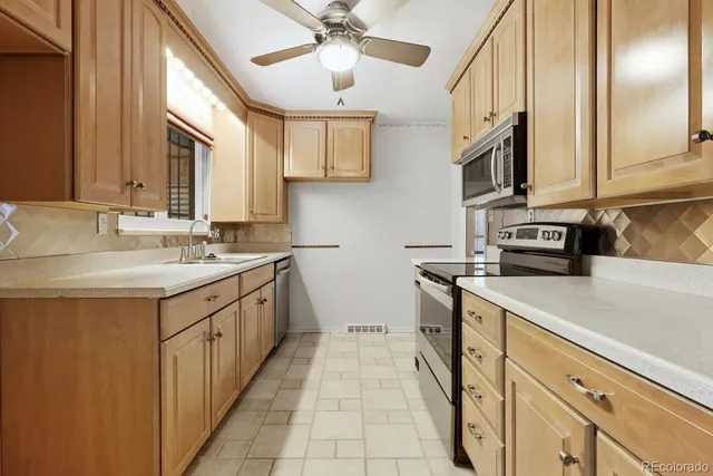 a kitchen with stainless steel appliances a sink stove and cabinets