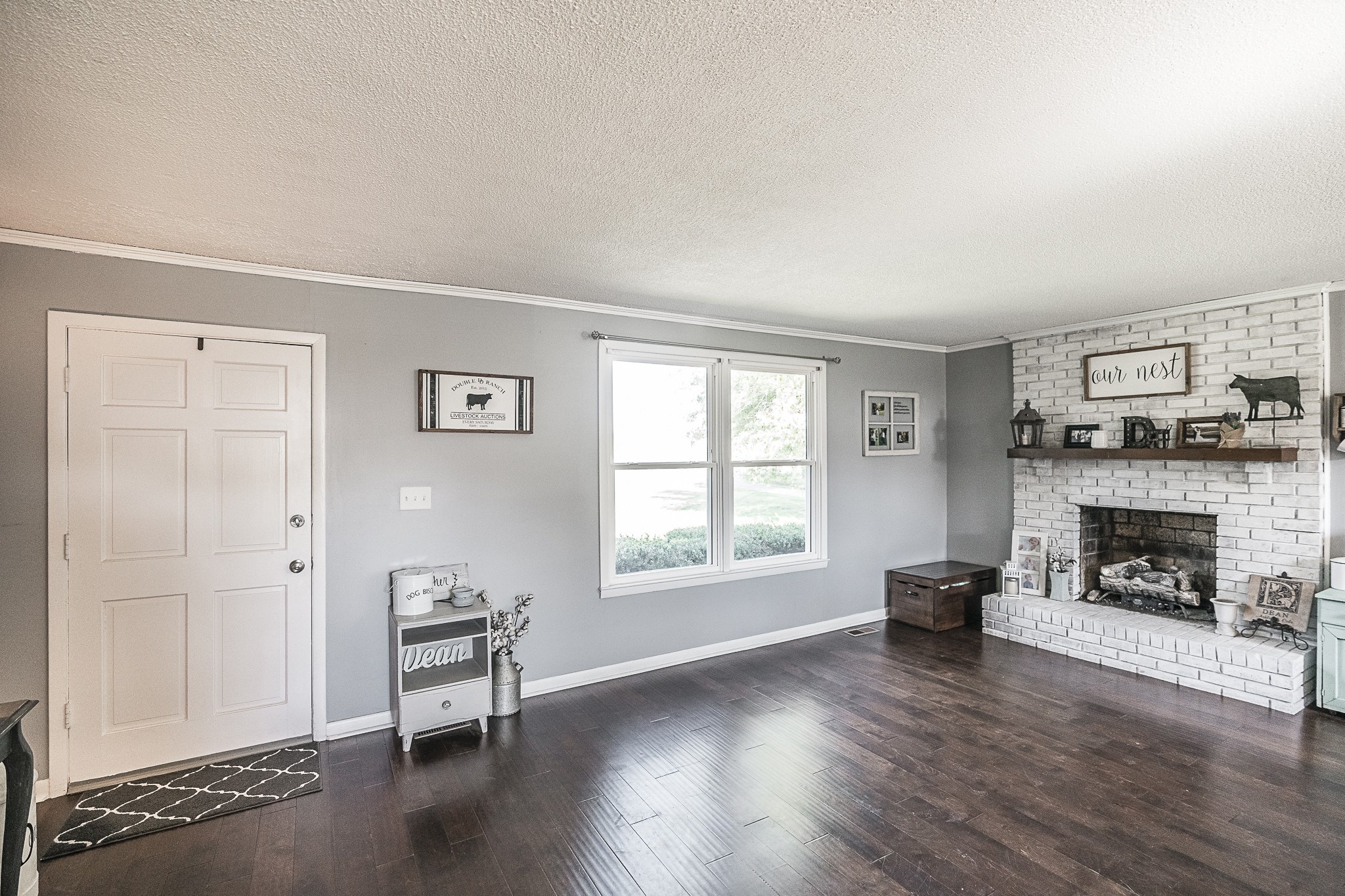 4451 Roy Cole Road Springfield, TN 37172 - Photo 7 of 43 an empty room with windows a fireplace and wooden floor