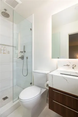 a bathroom with a sink a toilet and shower