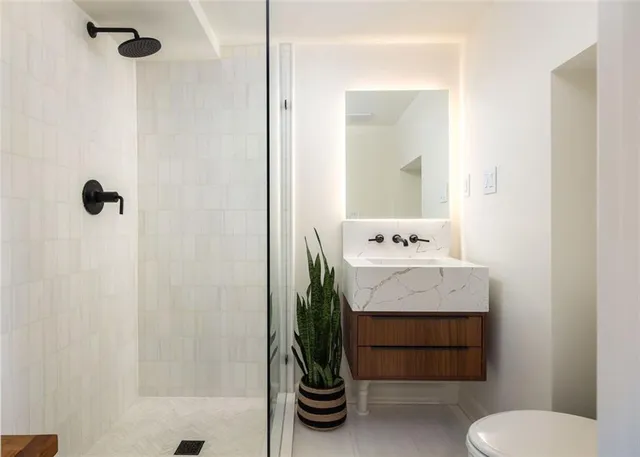 a bathroom with a sink a toilet and shower