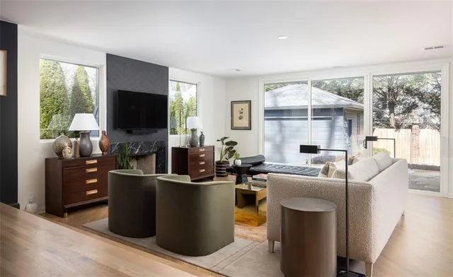 a living room with furniture a flat screen tv and a floor to ceiling window