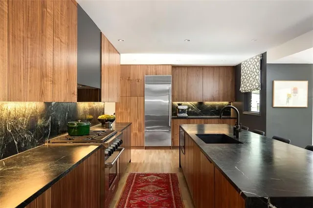 a kitchen with stainless steel appliances granite countertop a sink a stove and a refrigerator