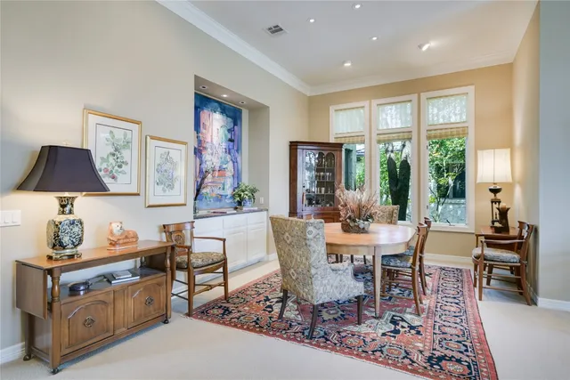 a dining room with furniture a rug and a floor to ceiling window