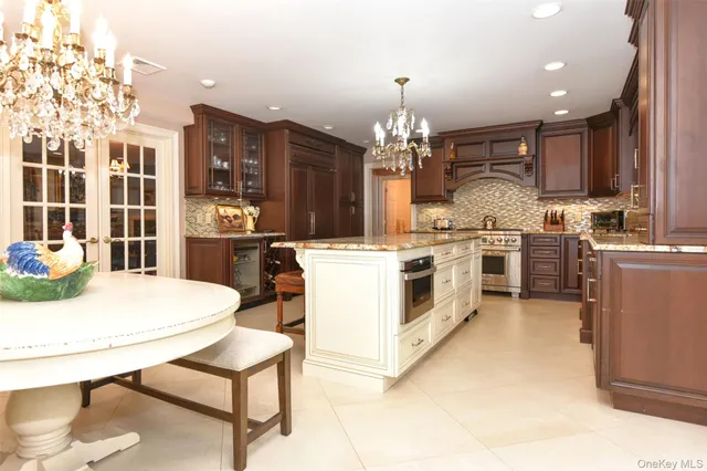 a kitchen with stainless steel appliances kitchen island granite countertop a stove a sink a refrigerator dining table and chairs