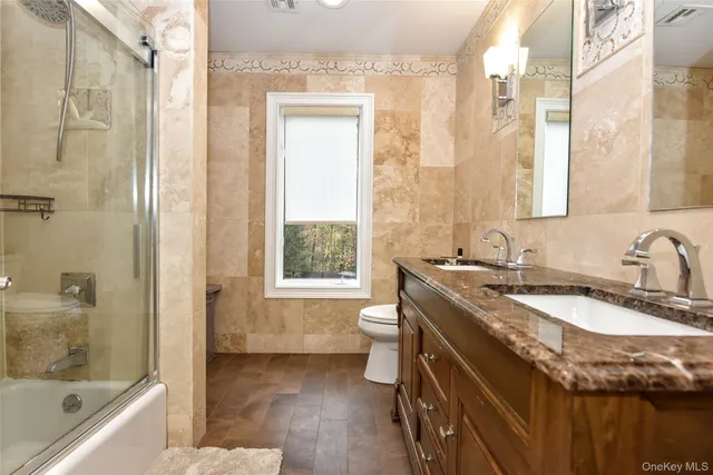 a bathroom with a granite countertop sink a toilet and shower