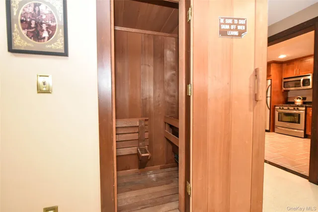 a view of a hallway with wooden floor and a bathroom