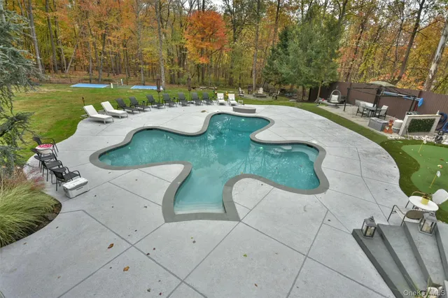swimming pool view with a seating space