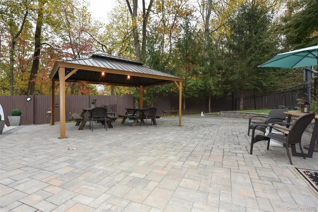 a view of backyard with a table and chairs under an umbrella
