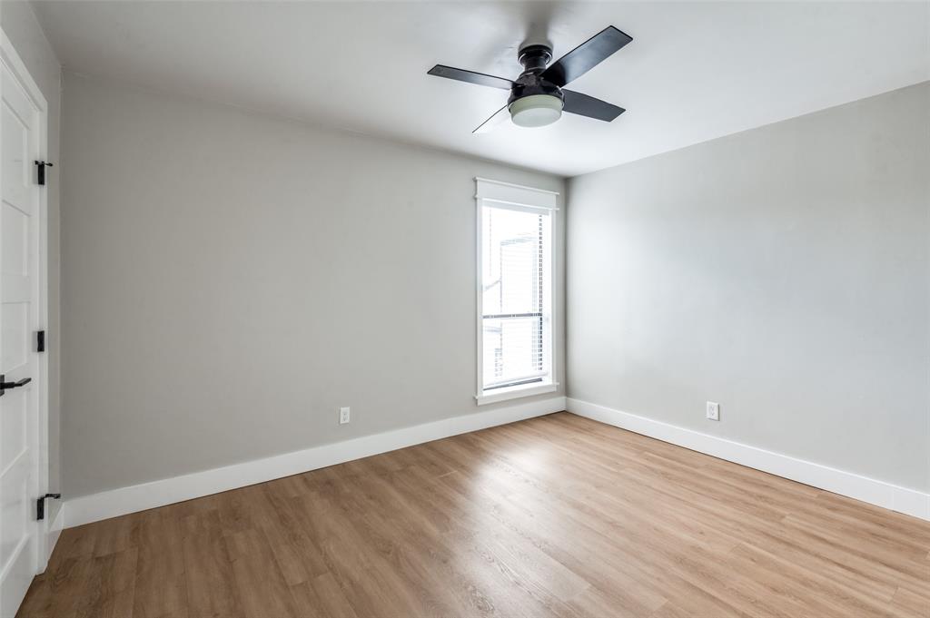 3022 Forest Lane, Unit 315 Dallas, TX 75234 - Photo 8 of 12 an empty room with wooden floor and windows