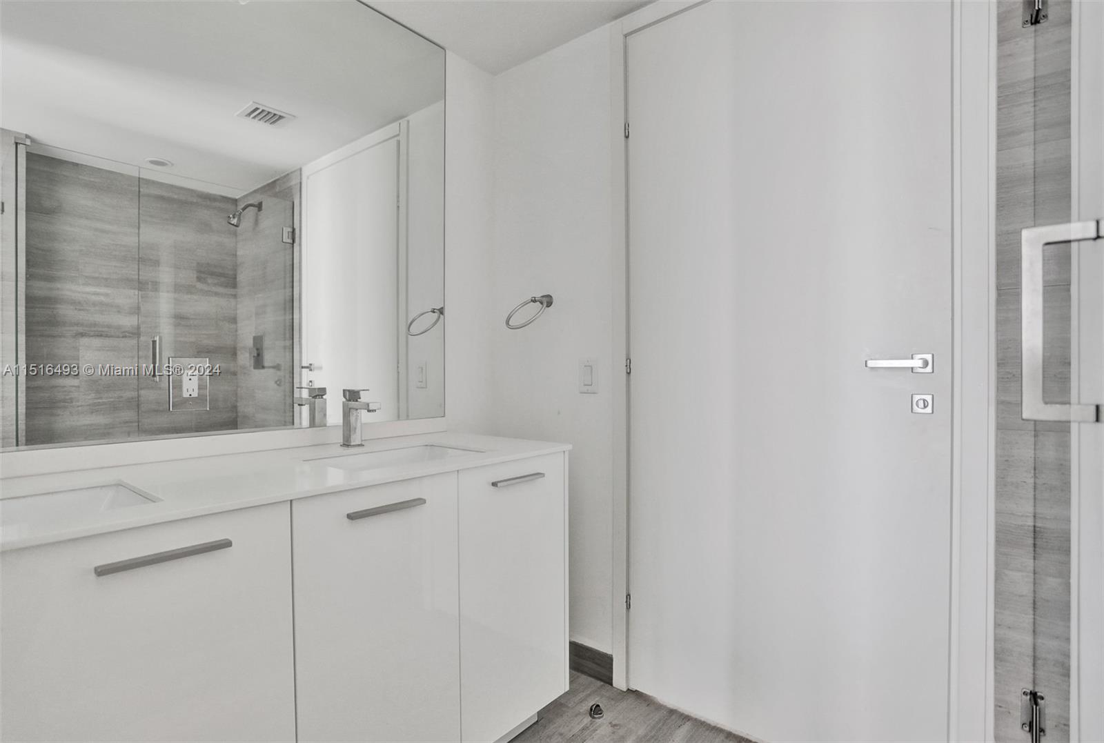 1300 Brickell Bay Drive, Unit 3003 Miami, FL 33131 - Photo 5 of 31 a bathroom with a granite countertop sink and a mirror
