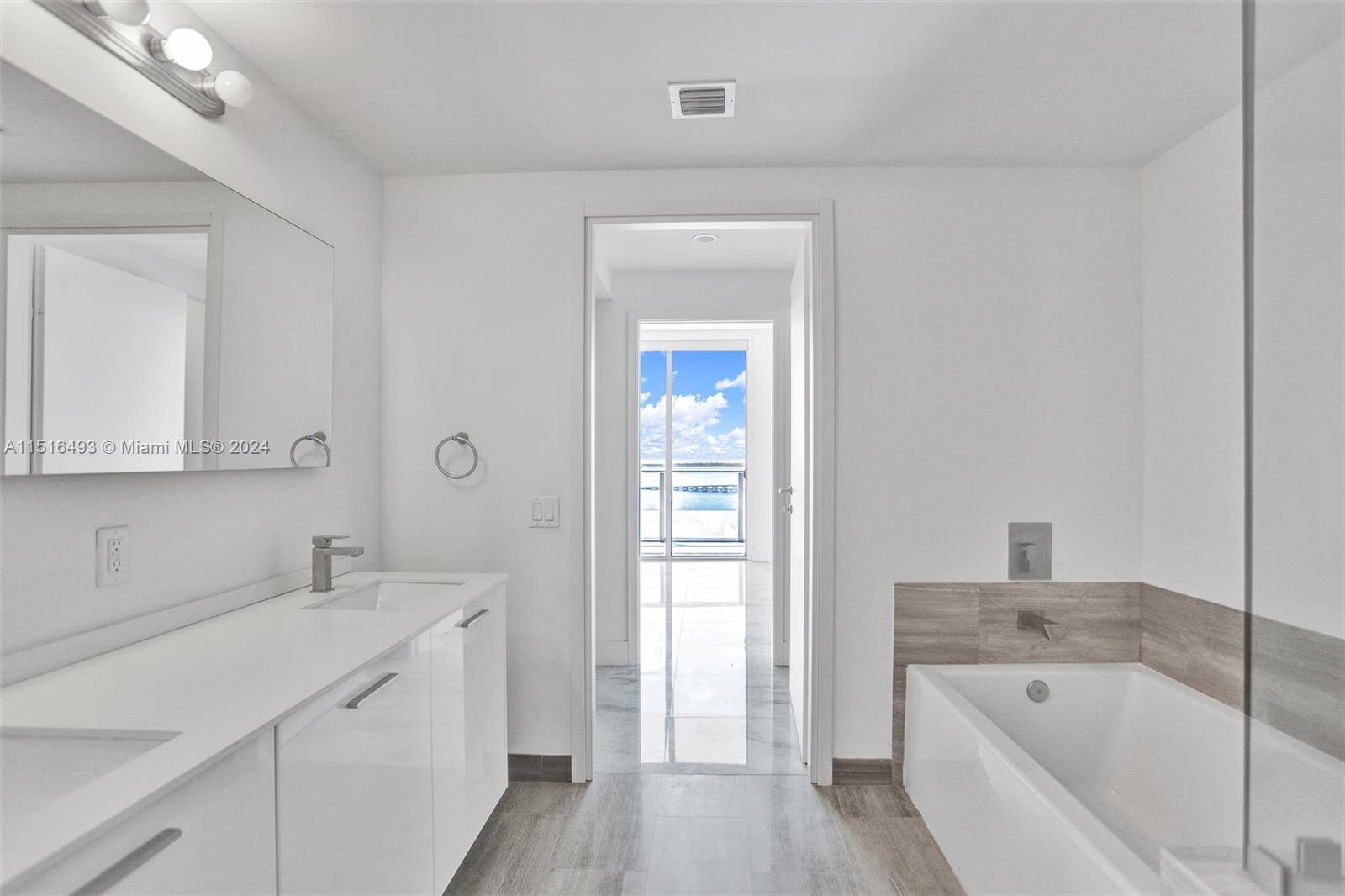 1300 Brickell Bay Drive, Unit 3003 Miami, FL 33131 - Photo 8 of 31 a bathroom with a tub sink and mirror