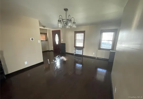 an empty room with windows and hardwood floor