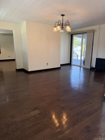 a view of a livingroom with wooden floor and a large window