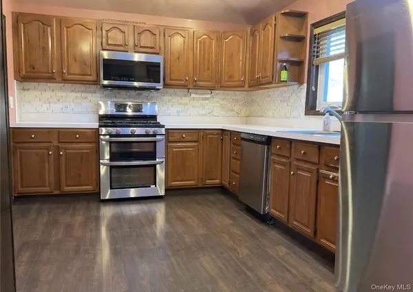 a kitchen with stainless steel appliances a stove microwave and sink