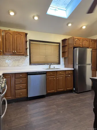 a kitchen with stainless steel appliances kitchen island granite countertop a refrigerator and a stove top oven