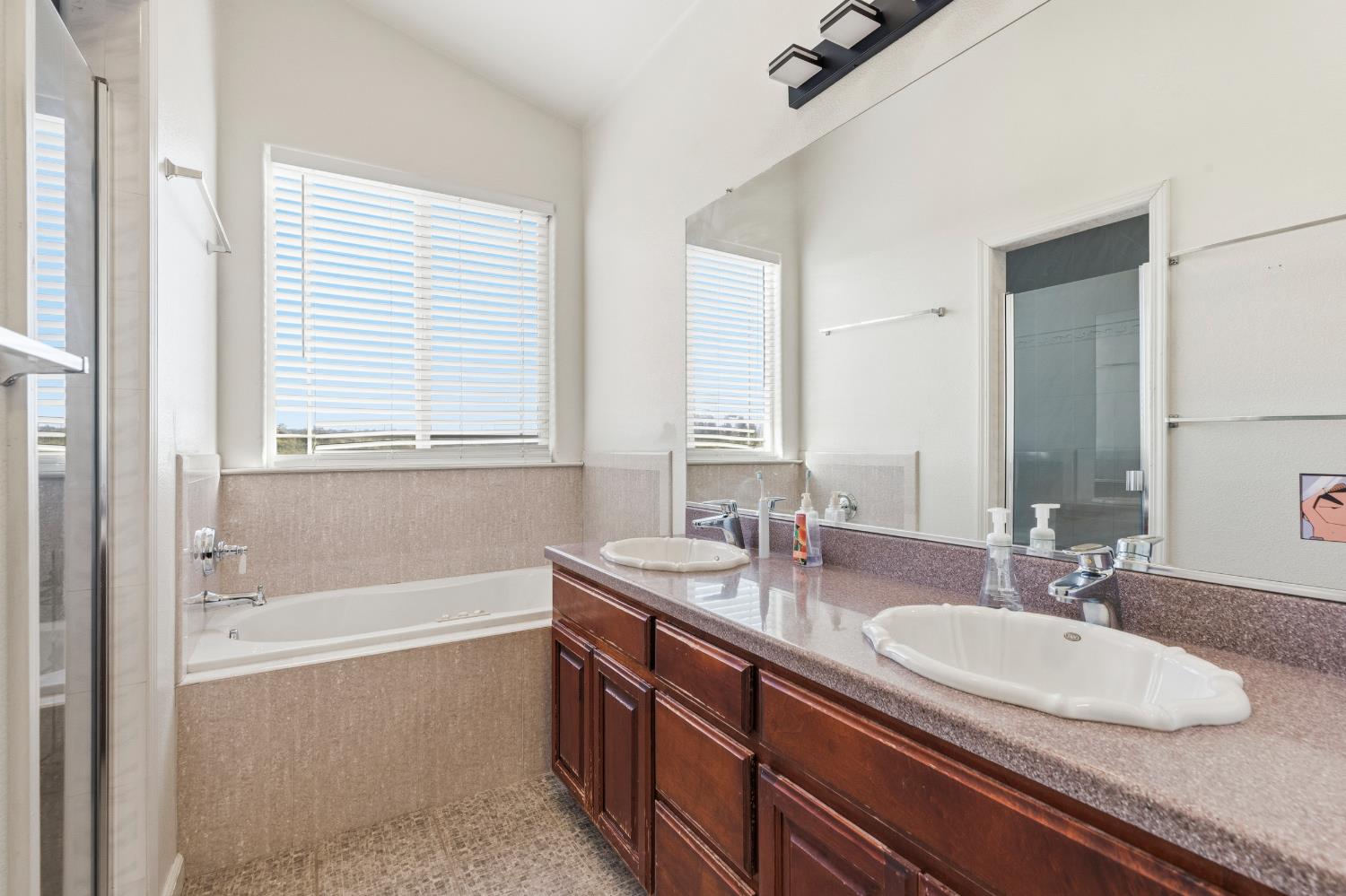 2000 Nita Alexander Court Modesto, CA 95358 - Photo 19 of 33 a bathroom with a granite countertop tub sink and mirror