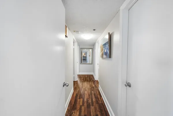 a view of a hallway with wooden floor