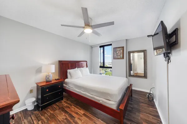 a bedroom with a bed and a flat tv screen on dresser