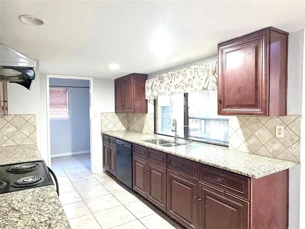 a kitchen with granite countertop a sink cabinets and window