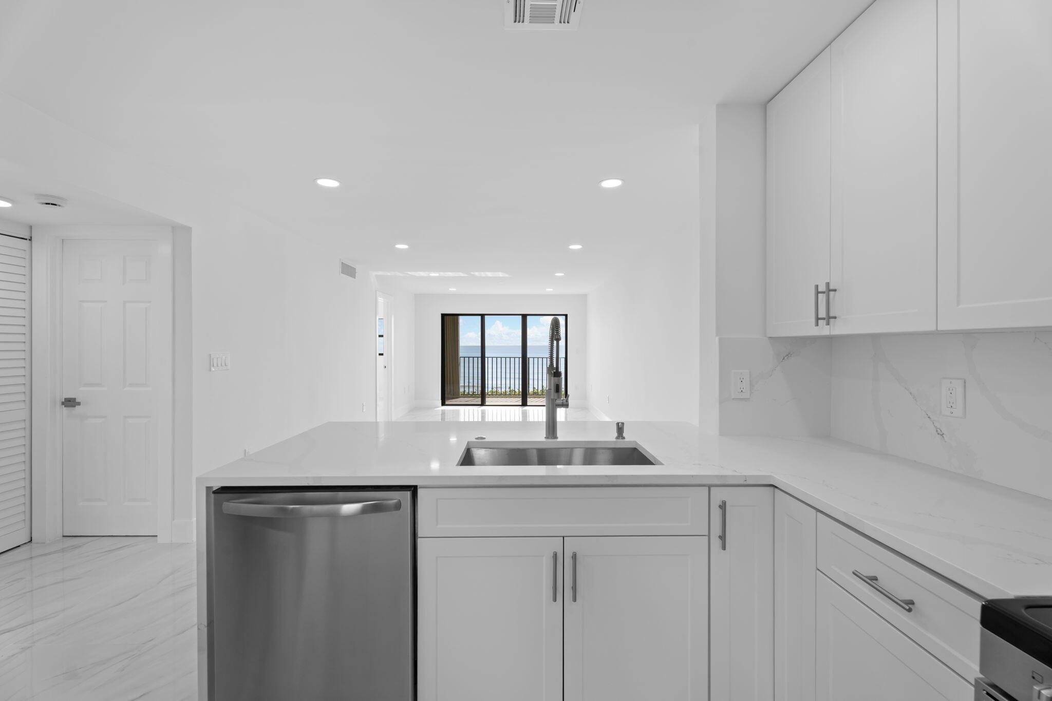 7420 South Ocean Drive, Unit 314 Jensen Beach, FL 34957 - Photo 5 of 24 a kitchen with granite countertop white cabinets and white appliances