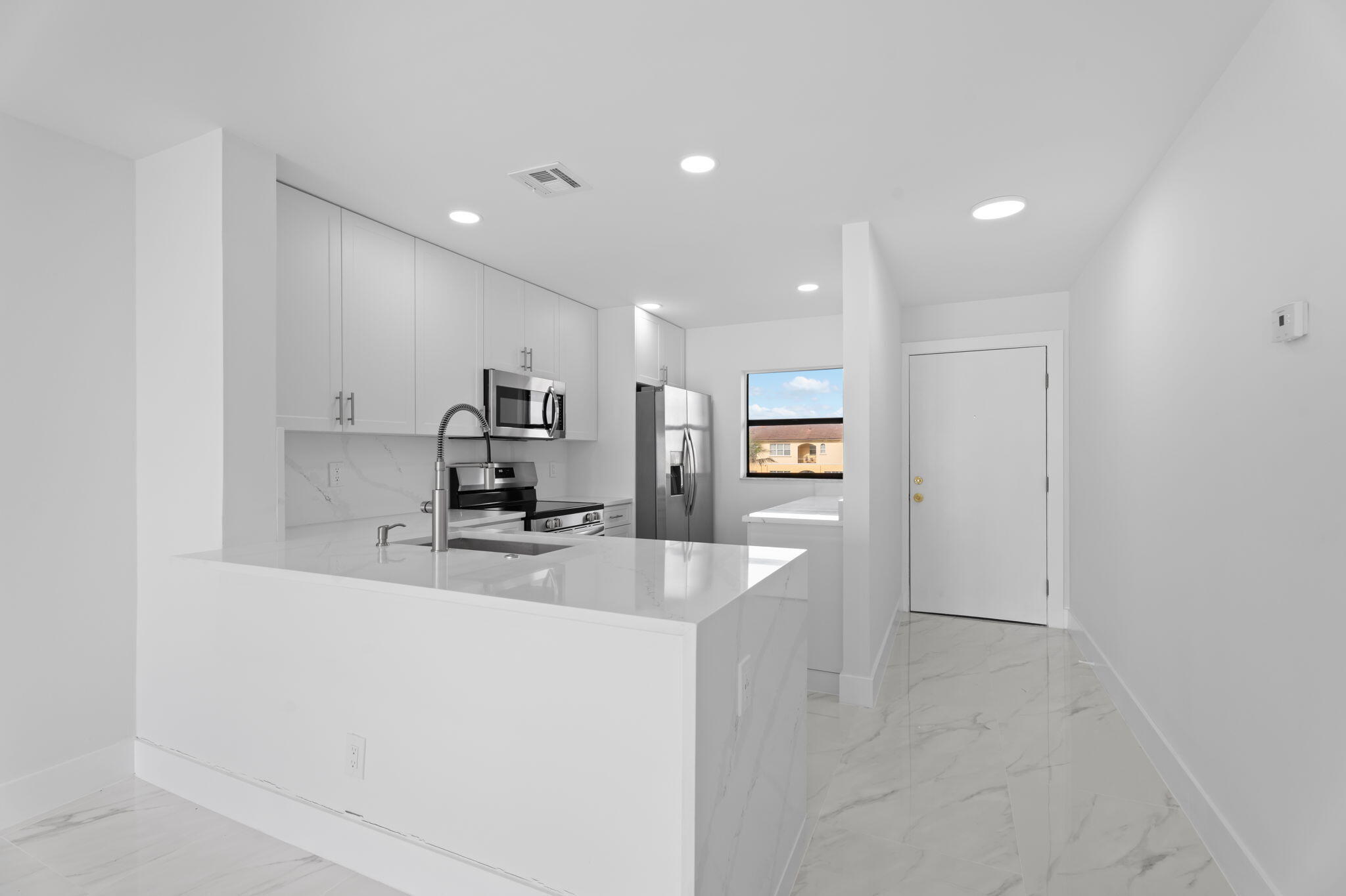 7420 South Ocean Drive, Unit 314 Jensen Beach, FL 34957 - Photo 6 of 24 a large kitchen with a large counter top stainless steel appliances and cabinets