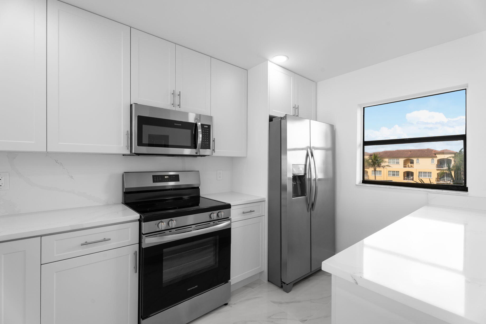 7420 South Ocean Drive, Unit 314 Jensen Beach, FL 34957 - Photo 7 of 24 a kitchen with a refrigerator stove and microwave