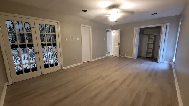 a view of an empty room with window and hallway