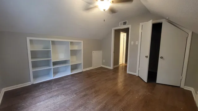 an empty room with wooden floor and closet