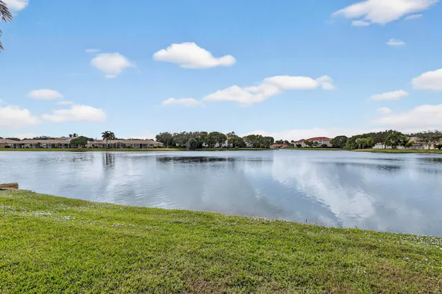 a view of a patio with table and chairs potted plants with floor to ceiling window and garden