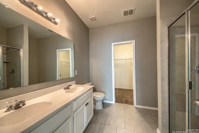 a bathroom with a double vanity sink toilet and a tub