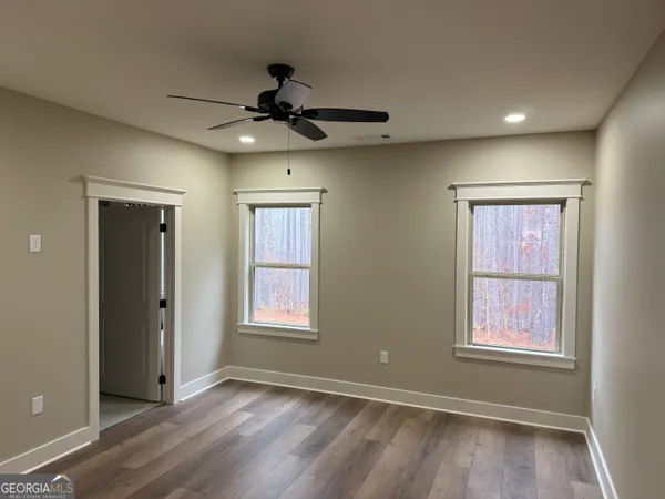 a view of an empty room with a window and wooden floor