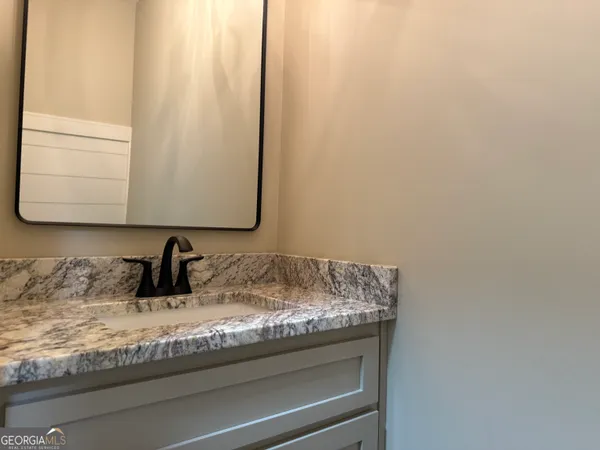 a bathroom with a granite countertop sink and a mirror