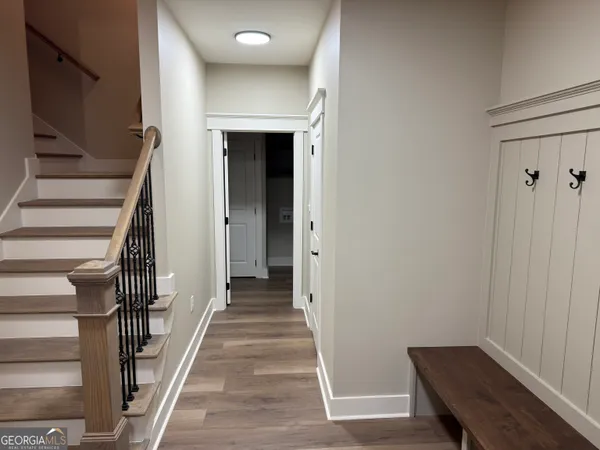 a view of a hallway with wooden floor and staircase