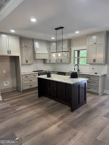 a kitchen with stainless steel appliances granite countertop a sink a stove and a refrigerator